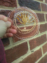 Load image into Gallery viewer, Beaded wire TOL Kippah  held against a brick wall to show the glass beading