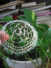 Load image into Gallery viewer, Silver and blue beaded (crystal) wire kippah being held against a viny plant, with a bunch of books in the background