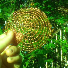 Load image into Gallery viewer, Beaded Copper wire  Renaissance style kippah, being held in hand against  greenleaves