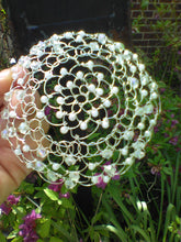 Load image into Gallery viewer, Crystal and pearl beaded wire kippah for woman. The kippah is held in front of a black mailbox, woth purpl flowers and green vines in the foreground and background.