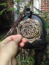 Load image into Gallery viewer, Beaded gold wire kippah being held against a black mailbox, with vines in the background