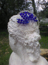 Load image into Gallery viewer, Silver and blue tree of life kippah rests on a bust of a woman. The bust is displayed outside, with a tree trunk, table, and more trees in the background.