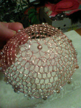 Load image into Gallery viewer, Rose gold wire kippah with peachy pink crystals and pearls  on white with plant in background.