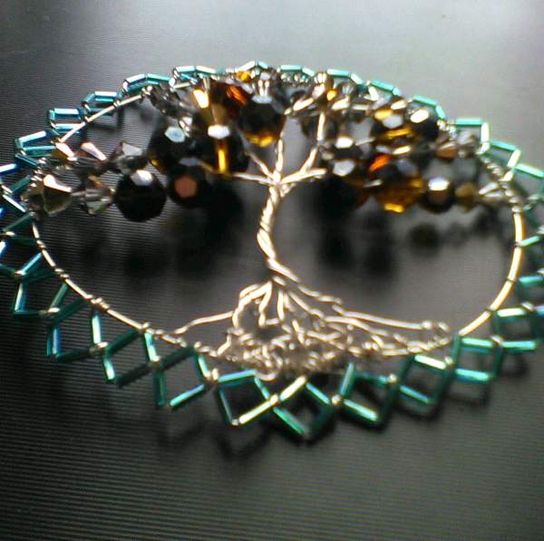 Silver wire tree of life wall hanging with beading in shades of light to dark amber, with blue bugle beads all around the piece.