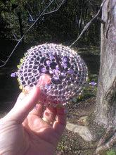 Load image into Gallery viewer, Purple and Green beaded silver wire kippah being held  n front of a tree  in early spring
