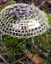 Load image into Gallery viewer, Spring colors of purple and green on silver wre crochet form a kippah that is right at home in nature. Shown here on some green moss with a mix of brown and green leaves in the foreground.d

