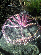 Load image into Gallery viewer, The pink and rose gold Tree of Life Kippah irests on a gray rock. There are dry leaves and green shoots behind it.
