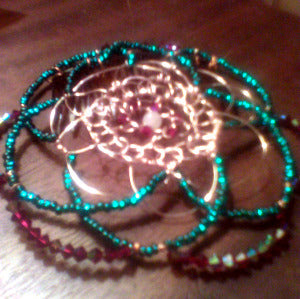 Teal glass beading and bugundy crystals form the petals of this flower inspired kippah/yamulke/heacovering. A lone rose quart bead rests at the focal. A comb is attached underneath