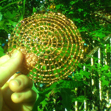 Load image into Gallery viewer, Beaded Copper wire  Renaissance style kippah, being held in hand against  greenleaves
