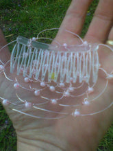 Load image into Gallery viewer, A clear comb is attached to the back of the kippah, which is shown on the palm of a hand
