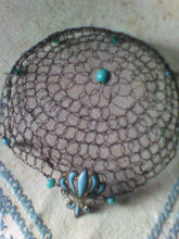 Load image into Gallery viewer, Black wire kippah   with turquoise beading and fleur-de-lis charm on a blue and white  embroidered tablecloth
